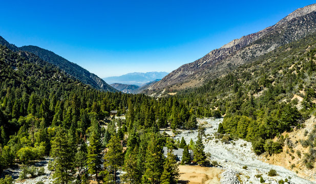 Aerial view of Forest Falls and Oak Creek in the San bernardino Mountains and National Forest with blue sky, green and yellow trees and plants