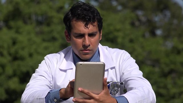 Serious Hispanic Doctor Using Tablet