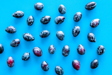 Purple plum pattern on blue background top view