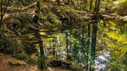 Fototapeta premium Beautiful pond in the forest Lacul Ochiul Beiului, Romania. National park Nerei beusnita. Autumn with beautiful colors.
