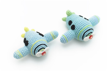 2 small crocheted blue planes for a child on a white background