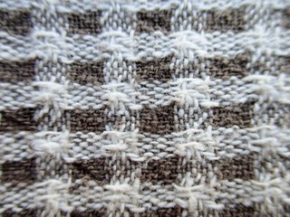 Detail of a kitchen towel, creating a taupe and white check background.