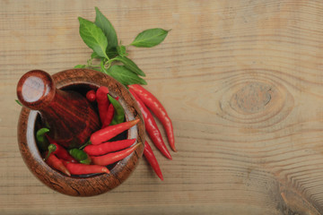 chili pepper in wooden mortar on wooden background