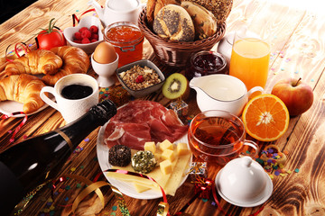 Fototapeta na wymiar breakfast on table with bread buns, croissants, coffe and juice on new years eve