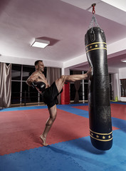 Muay thai fighter working with heavy bag