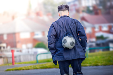 Back view of football soccer player going to training ground in afternoon alone
