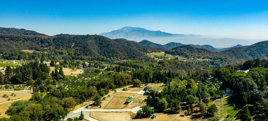 Aerial, drone view of Oak Glen located between the San Bernardino Mountains and Little San Bernardino Mountains with several apple orchards before the Fall color change © joel