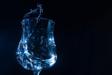 water in a glass goblet on a dark background