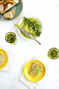 Overhead view of pesto served with sourdough bread and wine on table