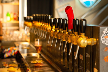 Draught beer on the tap at a pub counter