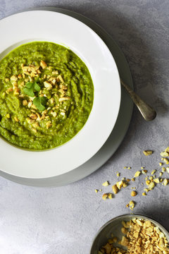 Partial view of broccoli soup in a bowl.
