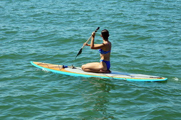 Attractive Young Woman Paddle Boarding