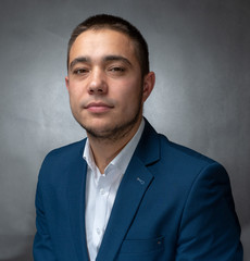 Handsome successfull  businessman in blue suit sitting and showing expressions
