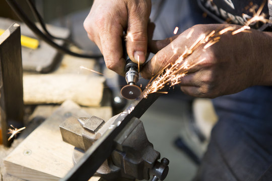 Artisan en train de graver une lame de couteau
