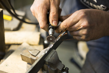 Artisan en train de graver une lame de couteau
