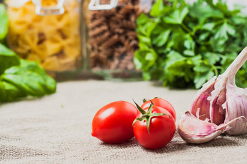 Ingredients for pasta - farfalle and fusilli, garlic, basil, cherry tomato
