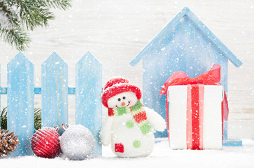 Christmas snowman toy, gift box and fir tree branch