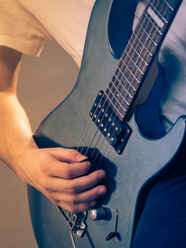 Close up of man playing on electric guitar
