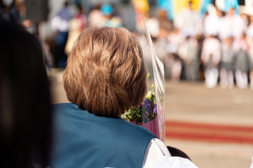 Almaty, Kazakhstan - September 1, 2018. The children are at the schoolyard with teachers. Children return to school. Kazakhstan on the first day of training, the teacher is standing and watching