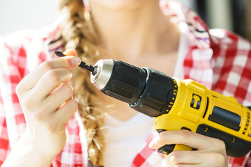 Woman using drill on window