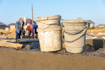 Fototapeta premium Workers lay the foundation for a new home