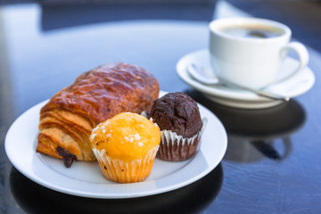Coffee cup and croissant on the table by the sea