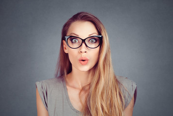 excited stunned woman in eyeglasses isolated on the  grey background