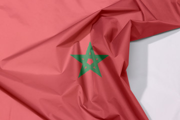 Morocco fabric flag crepe and crease with white space, red field with a black-bordered green...