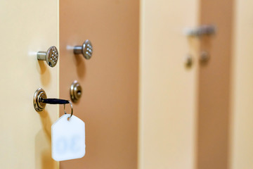 Wooden doors with key in sports gym locker room
