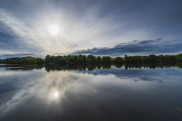 Wooded distant bank of the river in the evening.
