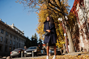 Stylish african american girl in blue coat posed at sunny autumn day. Africa model woman.