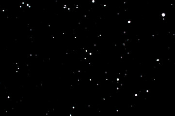 Snowstorm texture. Bokeh lights on black background, shot of flying snowflakes in the air