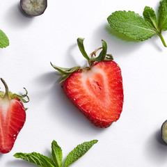 Fruits summer pattern with ripe strawberry, blueberry, leaf of mint on a white background.