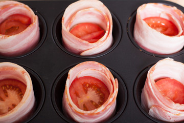 Cooking bacon egg muffins. Bread with tomato wrapped in bacon