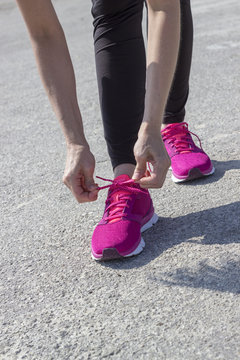 Girl Laces Up Pink Running Shoes