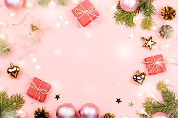 Fototapeta na wymiar Christmas background with fir branches, lights, red giftboxes, pink decorations with snow falling