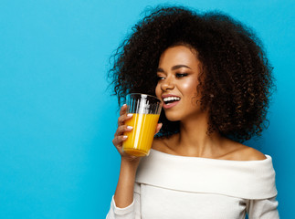 Beautiful african american girl with copy space drinking a orange juice
