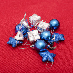 Christmas toys of blue and silver colors on red knitted fabric background