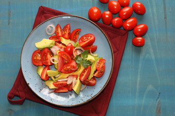 Fresh, healthy salad with tomatoes, avocado and onion.