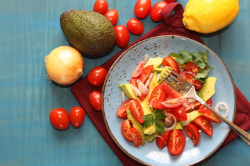 Fresh, healthy salad with tomatoes, avocado and onion.