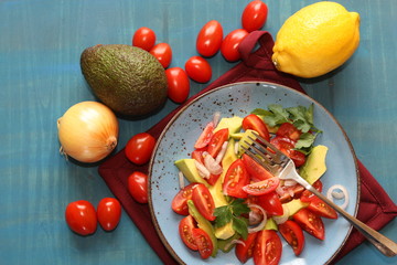 Fresh, healthy salad with tomatoes, avocado and onion.