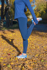 Beautiful sporty woman does sport exersices in the park, outdoors, soft focus background