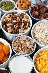 various cereals, nuts and dried fruits on wooden surface