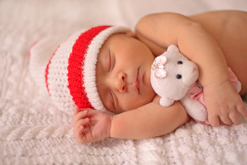 Newborn baby sleeps sweetly on a blanket.