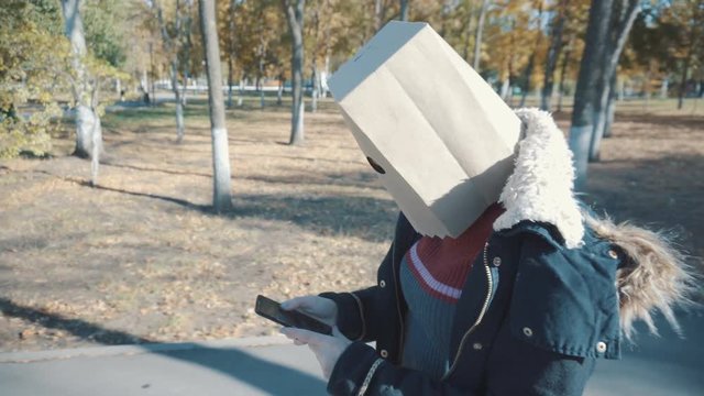 The girl with the package on her head walks with the phone