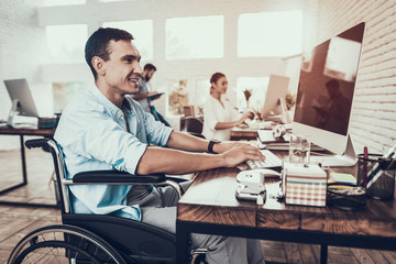 Man on Wheelchair Working on Computer in Office.