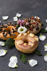 Set of three American unusual doughnuts decorated with flower leaves. Candy shop concept. 
