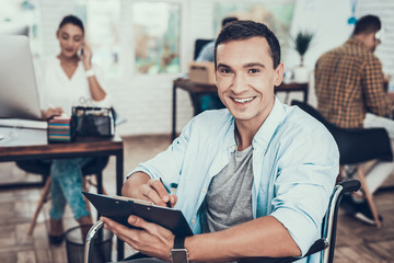 Disabled Man on Wheelchair with Tablet in Office.