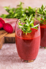 Bright beetroot smoothie in tumbler with fresh pieces of beet