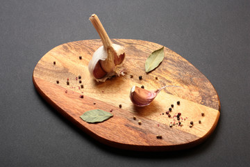 Garlic and spices on wooden cutting board